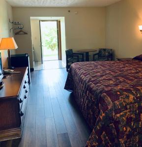 um quarto de hotel com uma cama, uma mesa e cadeiras em Landmark Inn em Sevierville