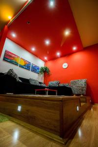 uma sala de estar com um sofá e paredes vermelhas em FLAMINGOS Apartman & Fitness OSIJEK - blizina Bolnice KBC Osijek em Osijek