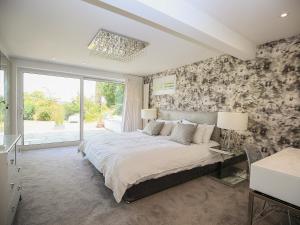 a bedroom with a large bed and a large window at Shutts House Garden Apartment in Salisbury