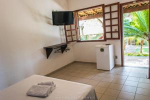 Habitación con nevera pequeña y ventana. en Pousada Recanto da Serra, en Serra do Cipo