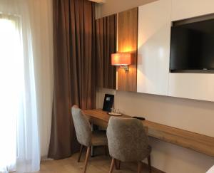 ein Hotelzimmer mit einem Schreibtisch mit 2 Stühlen und einem TV in der Unterkunft Hotel Rheinbrücke in Rheinfelden