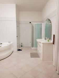 a white bathroom with a tub and a sink and a bath tub at B&B Tenuta Madiba in Ravenna +27 photos