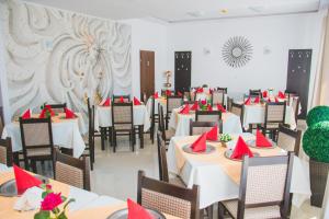 a dining room with tables and chairs with red napkins at Pensiunea Iliada in Sibiu