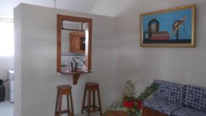un salon avec un canapé, un miroir et des tabourets dans l'établissement Palm Inn Hotel, à Port-au-Prince