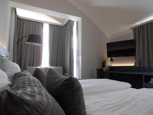 a hotel room with two beds and a television at Pension Elisabeth - Rooms & Apartments in Salzburg