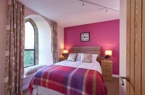 Dormitorio púrpura con cama y ventana en Chapel-on-the-Hill, en Grosmont