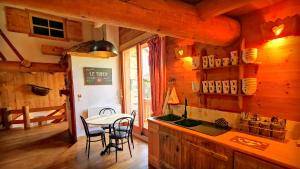 una cocina con mesa y fregadero en una cabaña en Cosy Lodge au pied de l'Alpe D'Huez SKi et Détente Jacuzzi Piscine Sauna Bar Billard, en Le Bourg-dʼOisans