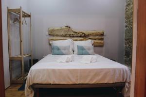 a bedroom with a bed with two slippers on it at Siglas & Runas II in Póvoa de Varzim