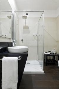 uma casa de banho com uma cabina de duche em vidro e um lavatório. em Palazzo Salgar em Nápoles