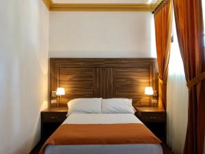 Un dormitorio con una cama con dos lámparas a ambos lados. en Hotel San Miguel, en Contepec