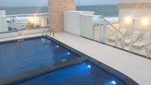 a swimming pool on top of a balcony with the ocean at Gaivotas Apart - Frente Mar in Florianópolis
