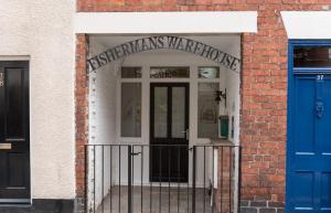 einen Eingang zu einem Backsteingebäude mit einer blauen Tür in der Unterkunft Fishermans Warehouse in Whitby + 2 Fotos