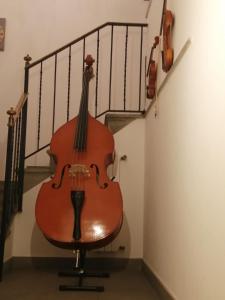 ベルガモにあるLa Maison Des Artistesの階段横の椅子に座るバイオリン