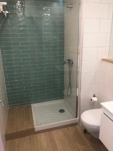 a bathroom with a green tiled shower with a toilet at Marsuites in Armação de Pêra +33 photos