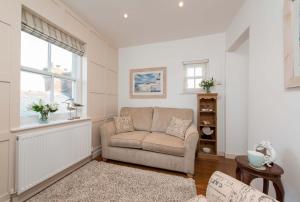 a living room with a couch and a window at Gavel Cottage in Whitby