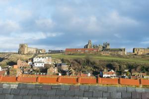 a view of a city with a castle in the background at Gavel Cottage in Whitby