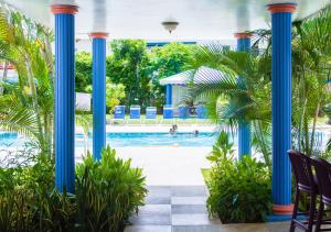 a view of the pool from the lobby of a resort with blue columns at Bay Gardens Inn in Gros Islet