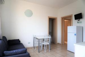 a living room with a couch and a table and a refrigerator at Villa Serena in Rosolina Mare