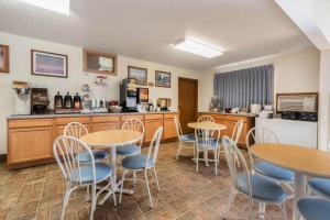 una sala con tavoli e sedie e una cucina di Super 8 by Wyndham Hill City/Mt Rushmore/ Area a Hill City