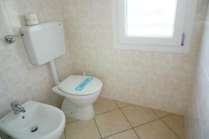 a bathroom with a toilet and a sink at Villa Serena in Rosolina Mare +8 photos