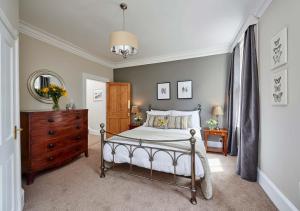 a bedroom with a bed and a dresser and a mirror at Harbour House in Whitby