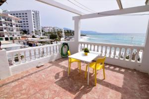een tafel en 2 stoelen op een balkon met uitzicht op de oceaan bij Casa Cava, C Merida 7 in Nerja