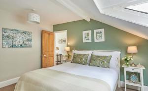 a bedroom with a white bed and green walls at Harbour House in Whitby