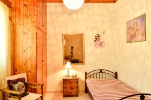 a bedroom with a bed and a mirror and a chair at Doloi garden house in Málta