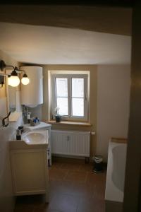 ein Bad mit einem Waschbecken und einem Fenster in der Unterkunft Klopstock´s Herberge in Quedlinburg