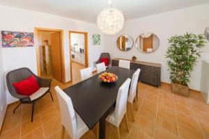 a dining room with a black table and white chairs at Porto Santo Blue House in Porto Santo +17 photos