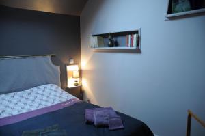 een slaapkamer met een bed met twee handdoeken erop bij Gîte Mi Do in Tourly