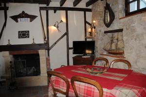 a dining room with a table and a boat on the wall at Gîte Mi Do in Tourly