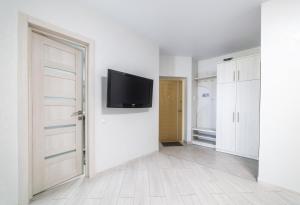 an empty room with a tv on a white wall at Apartments Roksolany 16 in Truskavets