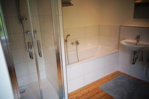 a bathroom with a shower and a tub and a sink at Ferienhaus am Moselsteig in Ürzig