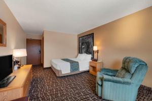 a hotel room with a bed and a chair at Super 8 by Wyndham Hill City/Mt Rushmore/ Area in Hill City