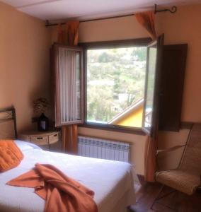 a bedroom with a bed and a large window at Apartamentos La Guergola in Pola de Somiedo