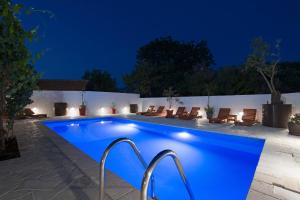 een zwembad in een achtertuin 's nachts bij Villa Cesarica in Tivat