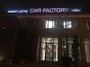 a sign on the front of a car factory at night at Loft Car Factory in Warsaw