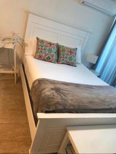een bed met twee kussens erop in een kamer bij Water Front Peaceful Apartment in San Juan