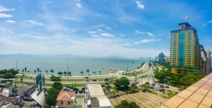 una vista de una ciudad con un edificio alto y el océano en Linda casa, en Florianópolis