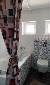 a bathroom with a toilet and a shower curtain at Sephora House in Stari Majdan