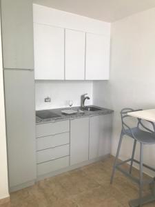een keuken met witte kasten, een wastafel en een tafel bij Water Front Peaceful Apartment in San Juan +6 foto's