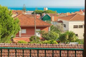 uma vista para uma cidade com casas e o oceano em Your Place in Estoril em Estoril