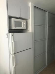 een keuken met een magnetron en een koelkast bij Water Front Peaceful Apartment in San Juan