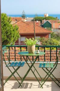 uma mesa e cadeiras numa varanda com uma planta em Your Place in Estoril em Estoril