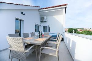 eine Terrasse mit einem Tisch und Stühlen auf dem Balkon in der Unterkunft Apartment Summer Fever in Zadar