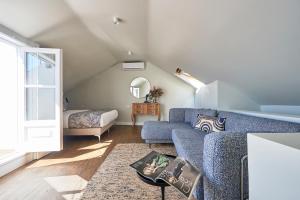 uma sala de estar com um sofá azul e uma cama em Lisbon Best Choice Apartments Alfama em Lisboa