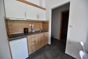 a kitchen with white cabinets and a sink at Lamda Deluxe Apartments in Keramoti