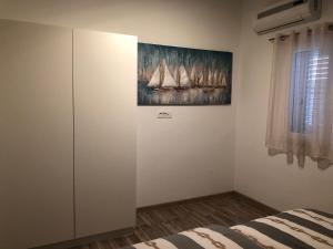 een slaapkamer met een schilderij van zeilboten aan de muur bij Ideal Holiday Apartment 1 in Tribunj