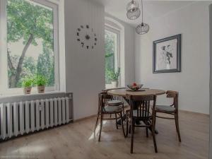 a dining room with a table and chairs and a clock at Apartament Nad Jeziorem Czos in Mrągowo